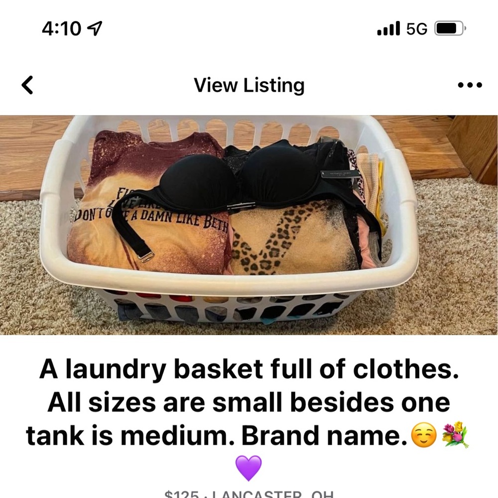 A laundry basket full of clothes. All sizes are small besides one tank is medium